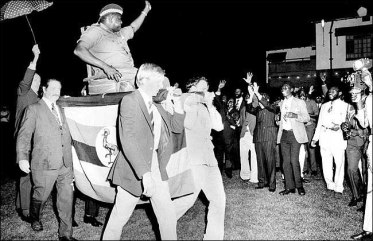 ** FILE **Ugandan President Idi Amin is carried in a chair by four British businessmen during a party for diplomats in this July 1975 file photo in Kampala, Uganda. A Swedish businessman holds an umbrella in the manner of servants who once shielded tribal rulers from the sun. Amin, whose eight years as president of Uganda were characterized by bizarre and murderous behavior, died Saturday, Aug. 16, 2003, according to a  hospital official in Saudi Arabia. Amin was 80. (AP Photo/File) ORG XMIT: NY17